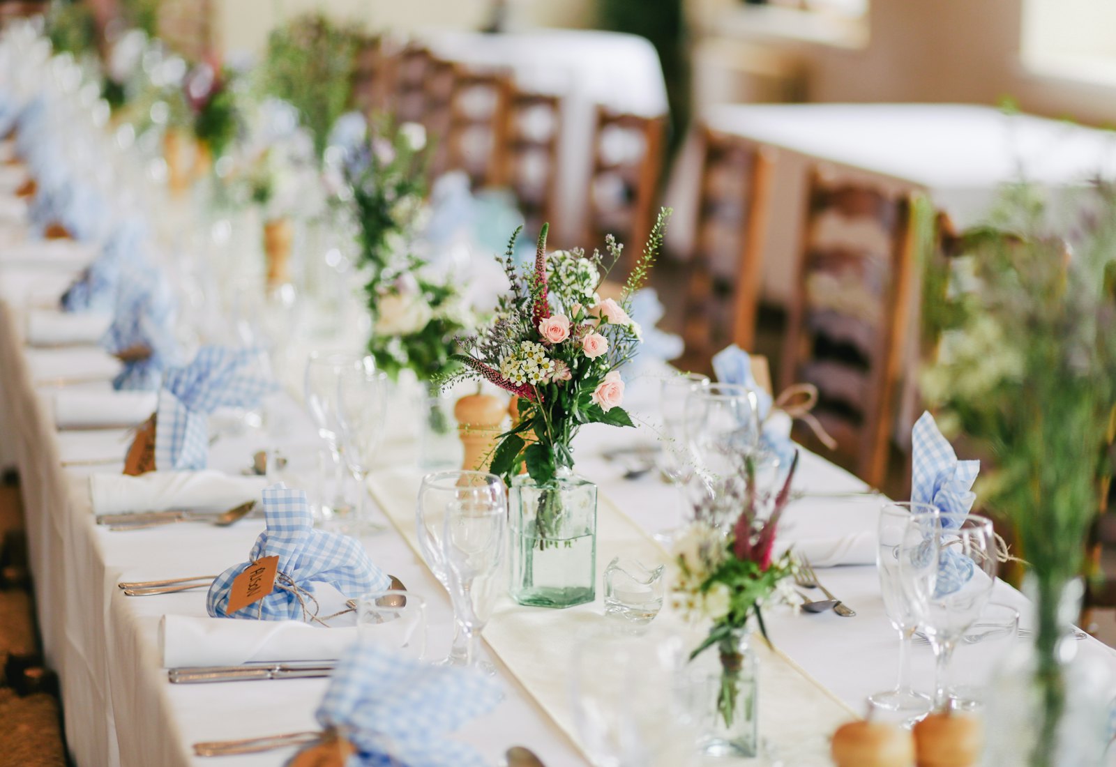 Réception de mariage élégante dressée avec fleurs et verdure